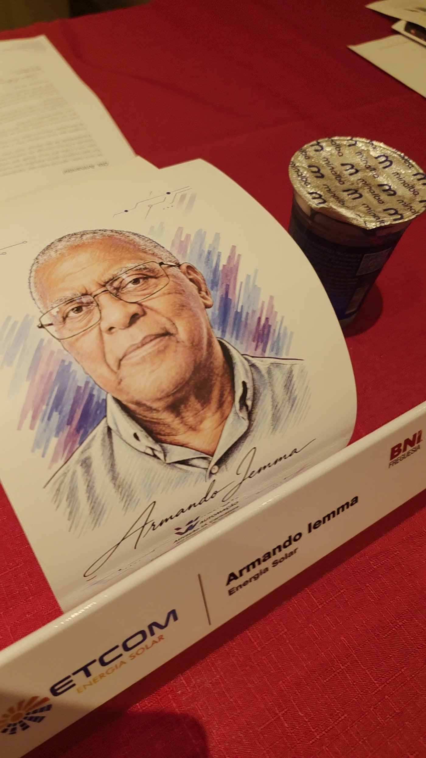 Caricatura colorida apoiada na plaqueta de nome de um dos convidados, na mesa montada antes do café