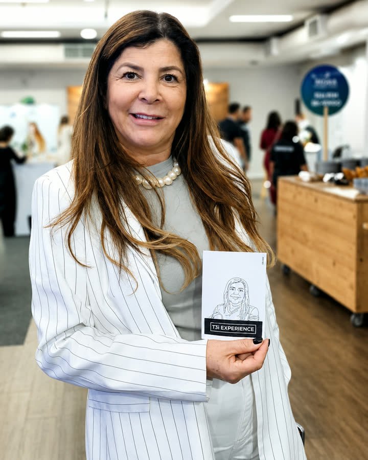 Participante segurando a caricatura desenhada pelo braço robótico
