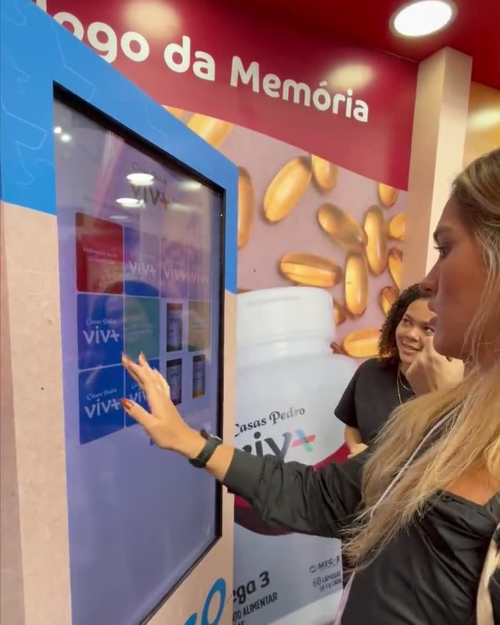 Participante jogando o jogo da memória no totem do estande