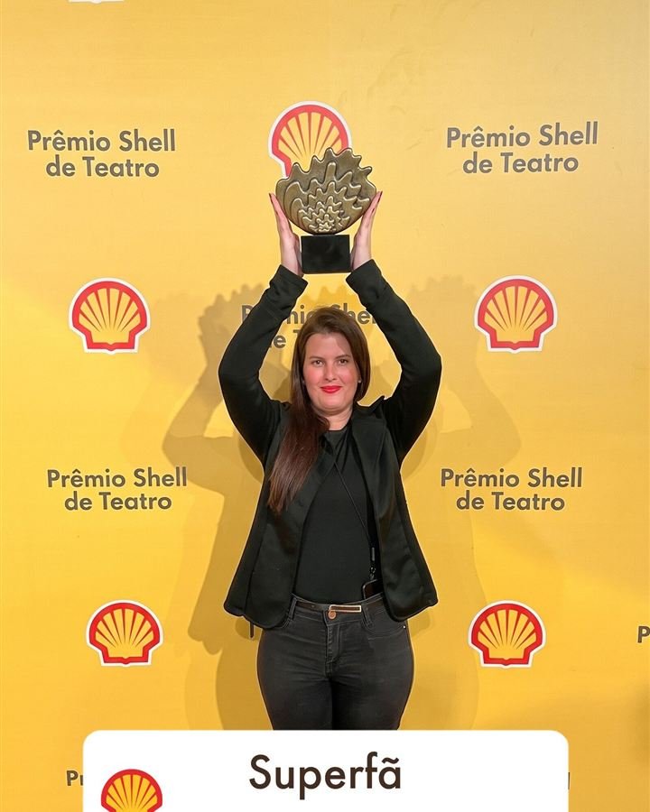 Participante erguendo o troféu inserido por IA
