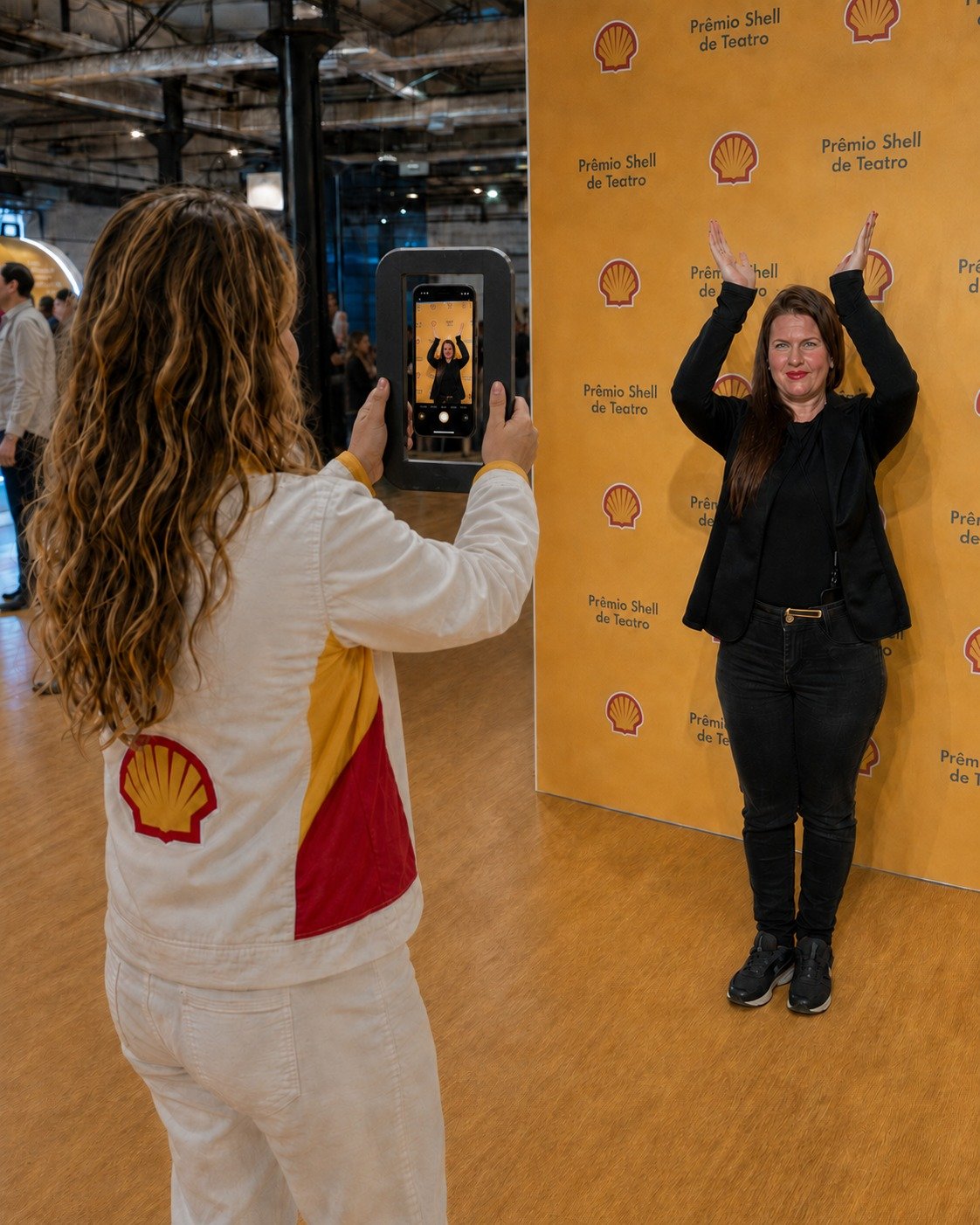 Team photographing the guest posing with arms raised at the event
